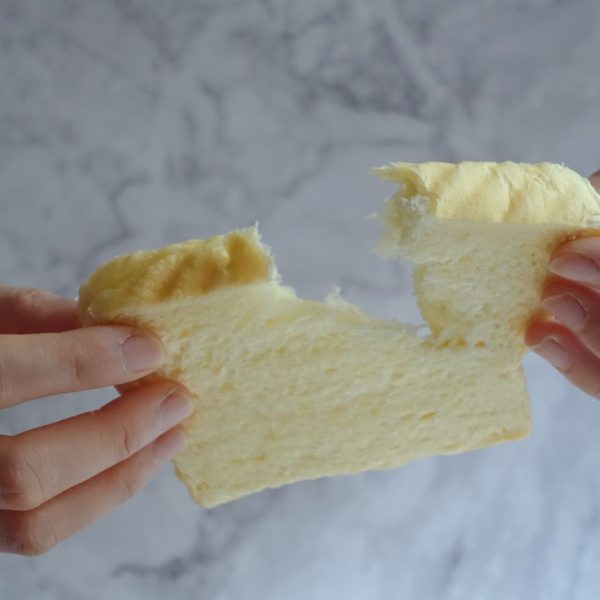 hands tearing off a piece of bread