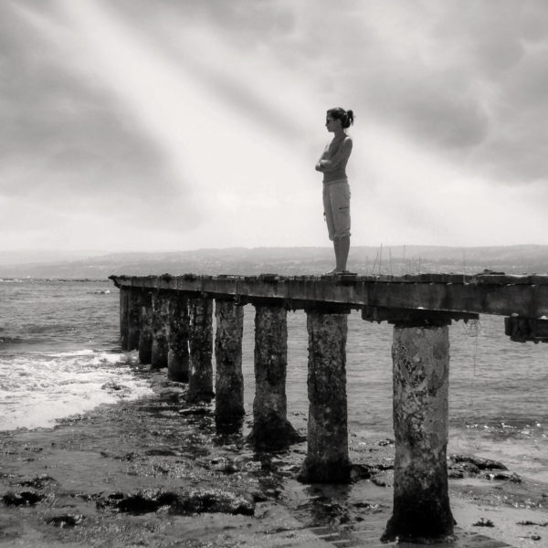 woman standing alone on a pier
