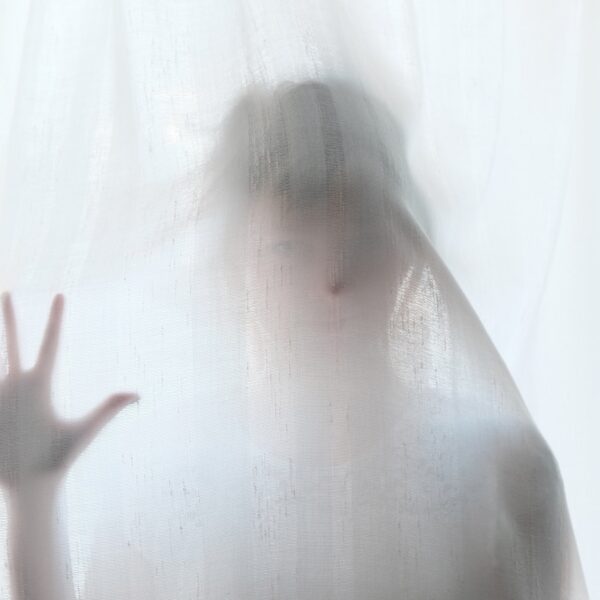 person hidden behind a veil